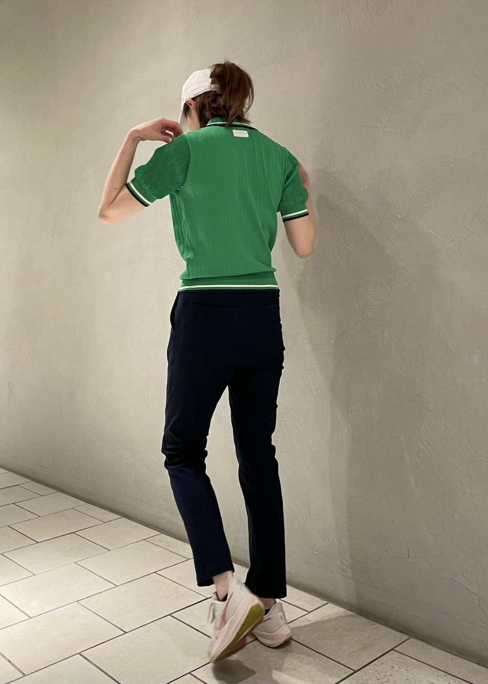 グリーン系のポロシャツ、ブルー系のその他パンツ、ホワイト系のキャップを着用したレディースの夏コーディネートの3枚目の写真