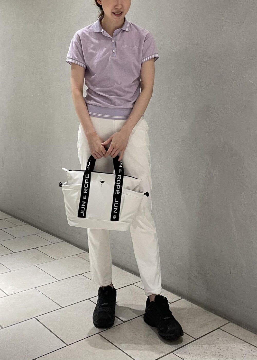 ホワイト系のハンドバッグ、ホワイト系のその他パンツ、パープル系のポロシャツを着用したレディースの春コーディネートの5枚目の写真