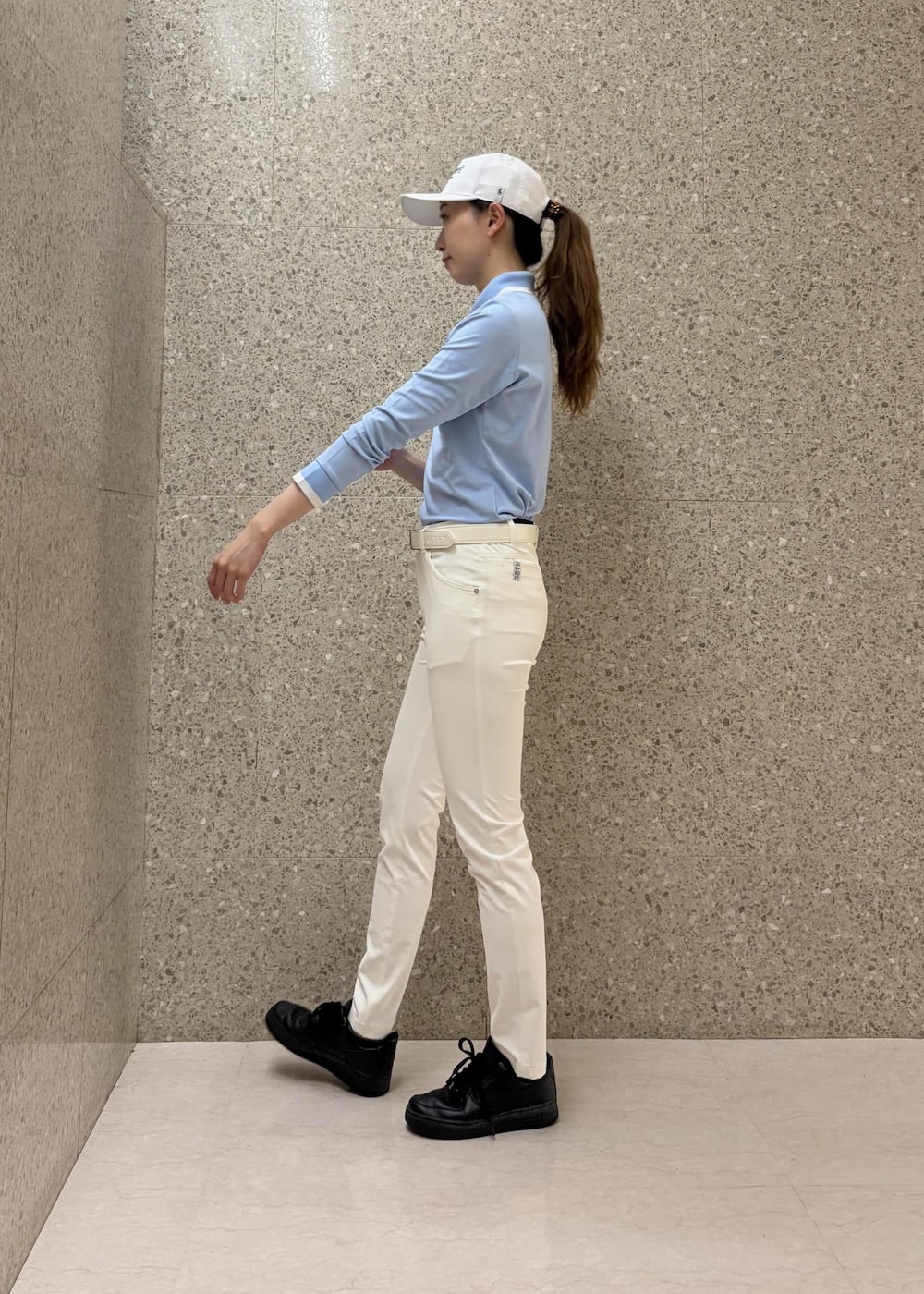 ブルー系のポロシャツ、ホワイト系のその他パンツ、ホワイト系のベルトを着用したレディースの秋コーディネートの4枚目の写真