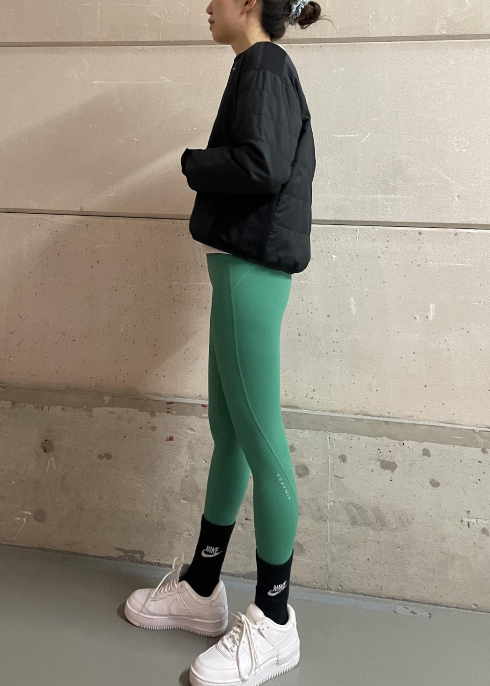 ホワイト系のスニーカー、ブラック系のブルゾン、グレー系のスウェットを着用したレディースの冬コーディネートの2枚目の写真