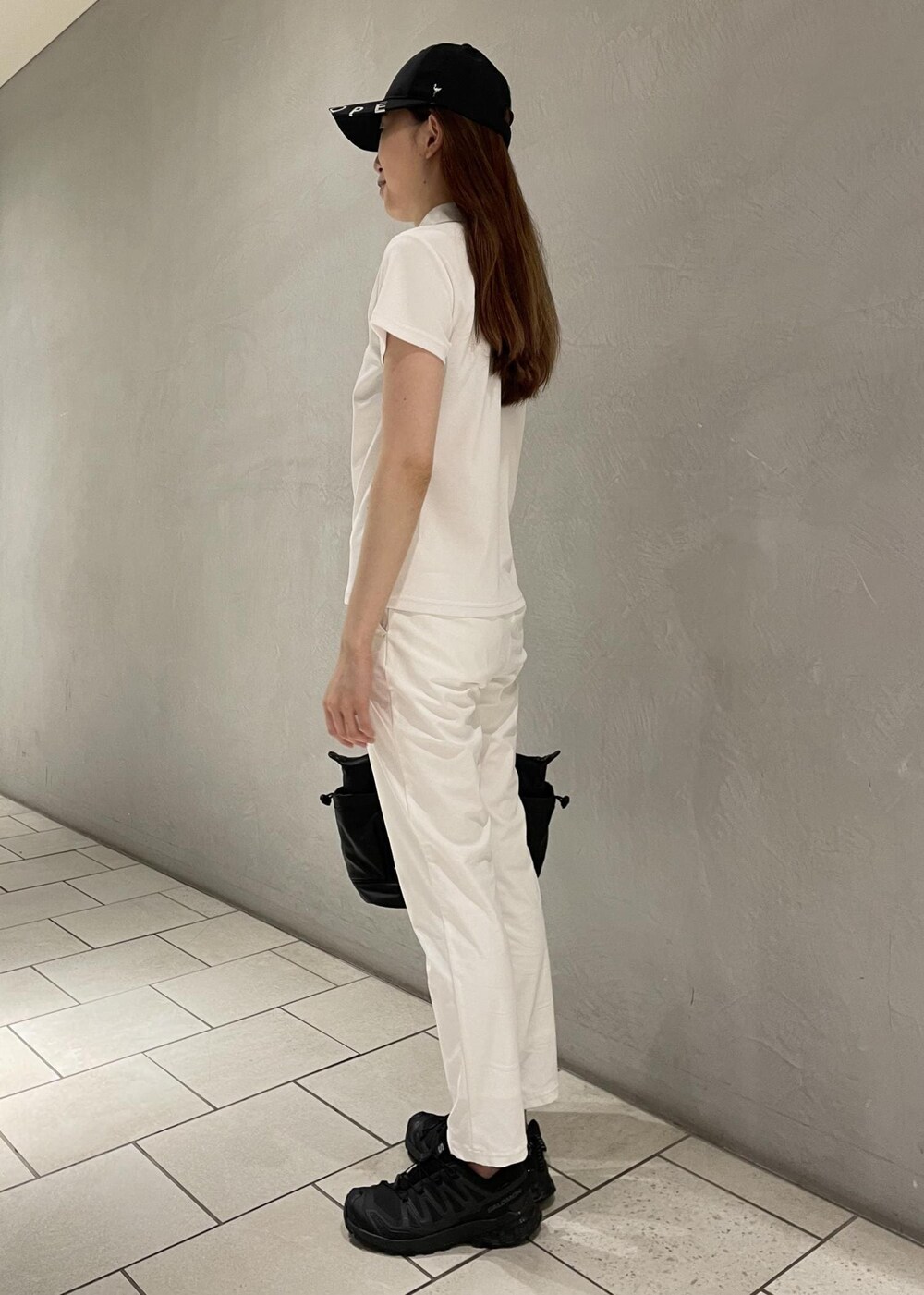 ブラック系のハンドバッグ、ホワイト系のその他パンツ、グレー系のポロシャツを着用したレディースの春コーディネートの3枚目の写真