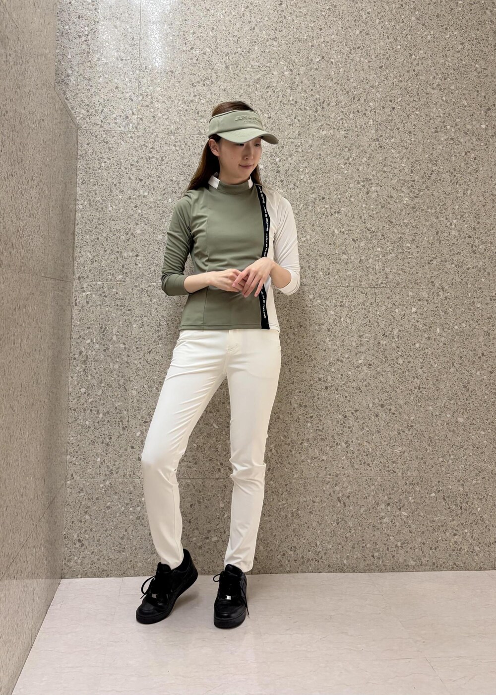 グリーン系のTシャツ/カットソー、ホワイト系のその他パンツ、グリーン系のサンバイザーを着用したレディースの秋コーディネートの6枚目の写真