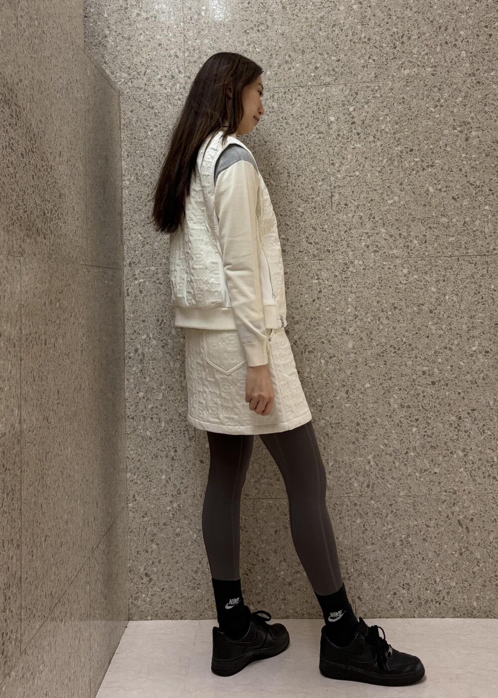 ホワイト系のTシャツ/カットソー、ホワイト系のブルゾン、グレー系のニット/セーターを着用したレディースの秋コーディネートの5枚目の写真