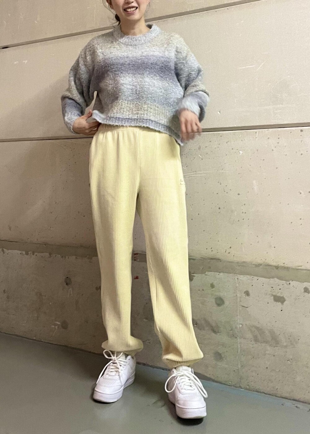 ホワイト系のスニーカー、ホワイト系のその他パンツ、グレー系のニット/セーターを着用したレディースの冬コーディネートの2枚目の写真