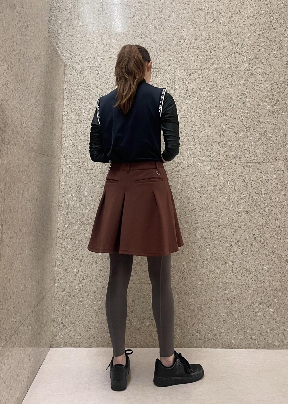 ブラック系のTシャツ/カットソー、ブラウン系のスカートを着用したレディースの秋コーディネートの3枚目の写真
