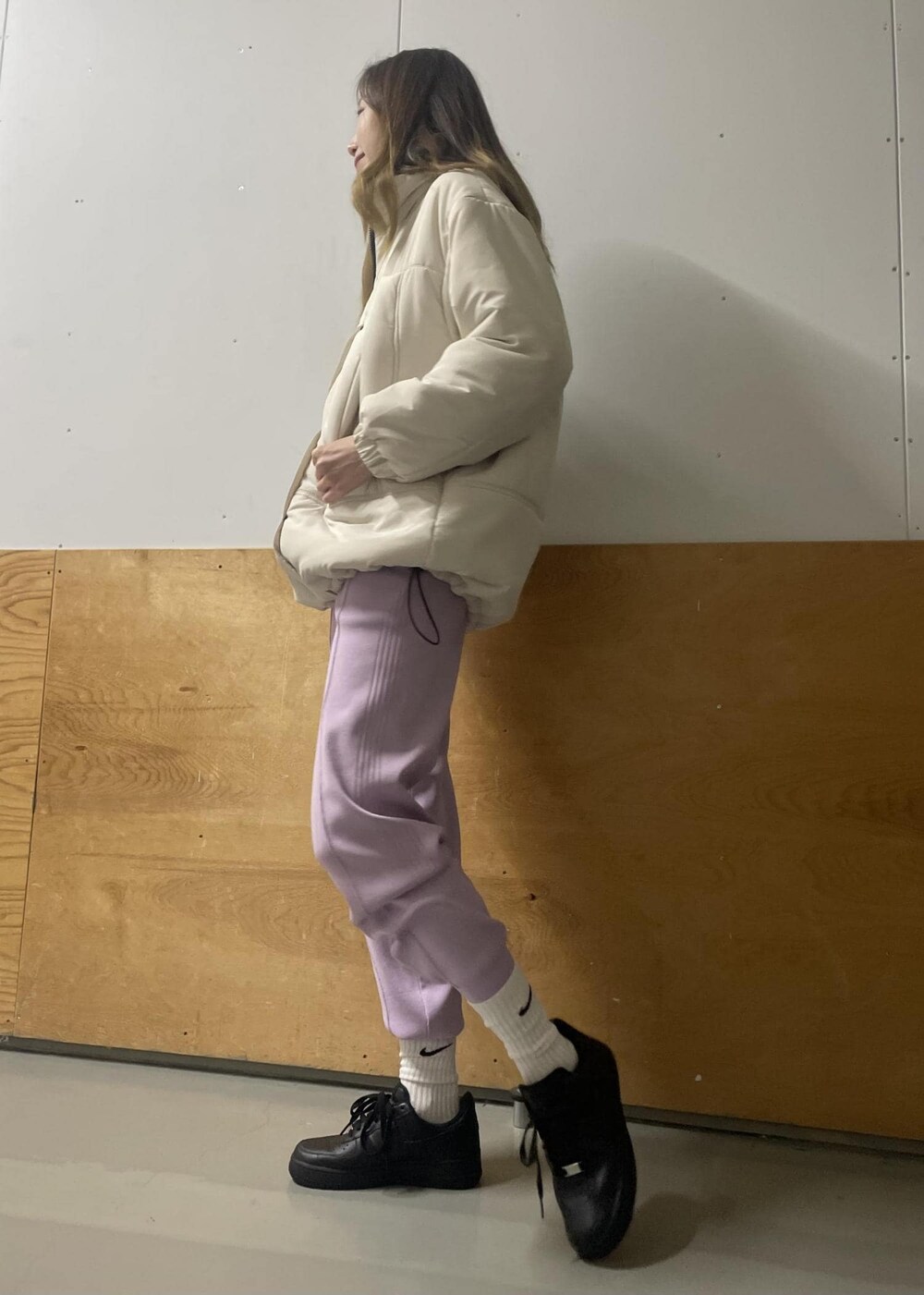 パープル系のその他パンツ、ホワイト系のダウンジャケット/コート、ブラック系のパーカーを着用したレディースの冬コーディネートの3枚目の写真