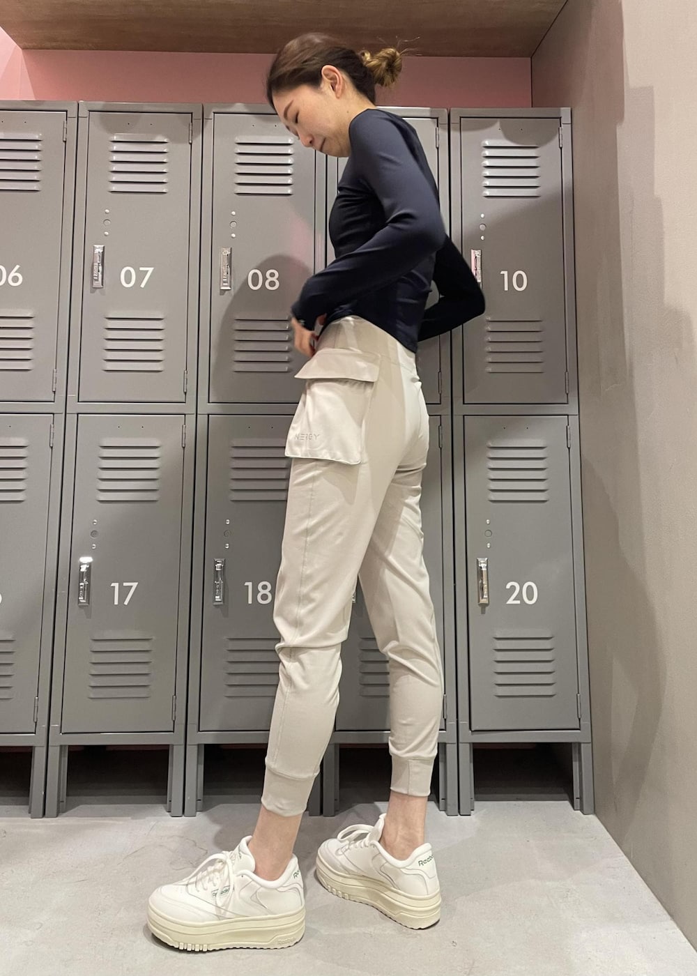 ブラック系のTシャツ/カットソー、ホワイト系のスニーカー、グレー系のレギンス/スパッツを着用したレディースの冬コーディネートの3枚目の写真