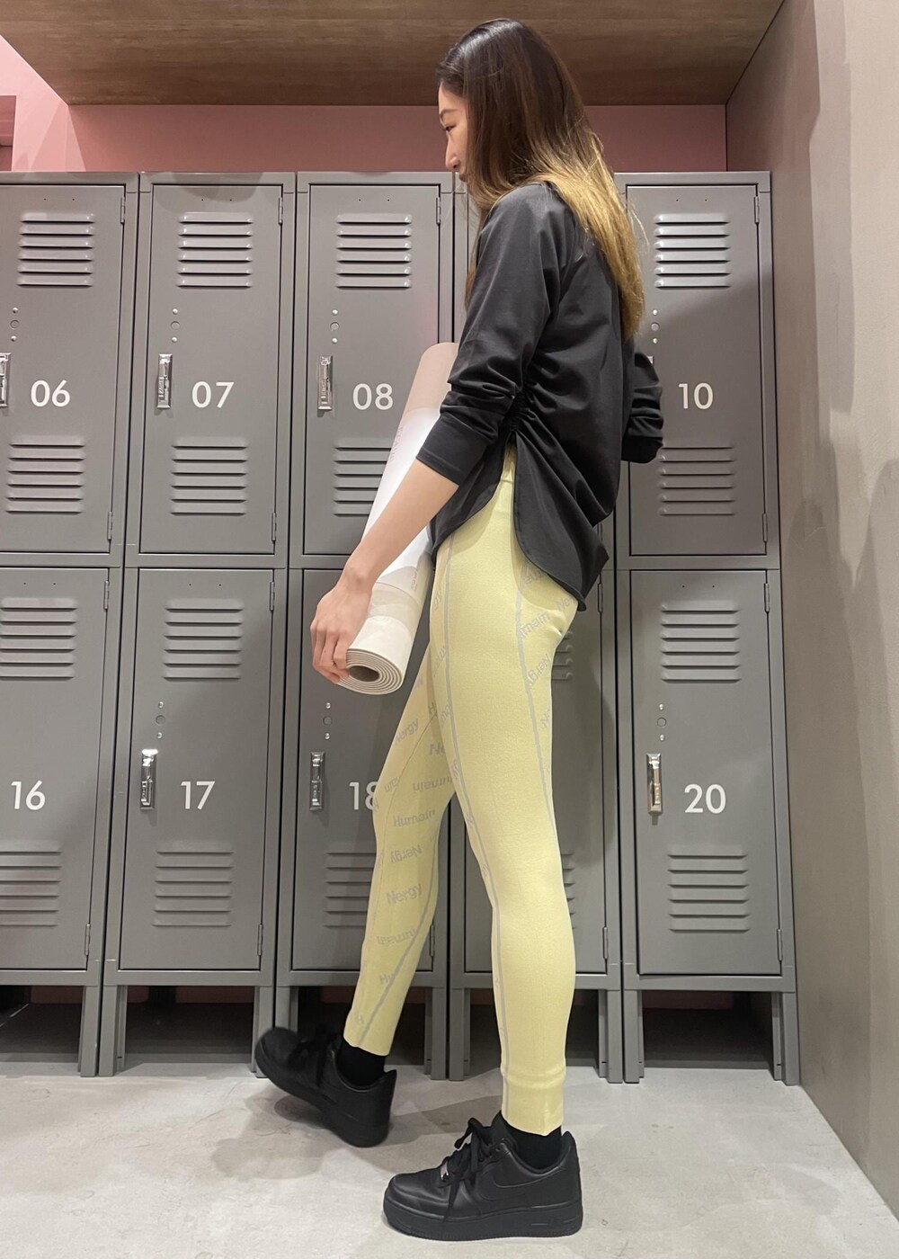 ブラック系のTシャツ/カットソー、ブラック系のスニーカー、イエロー系のレギンス/スパッツを着用したレディースの冬コーディネートの2枚目の写真