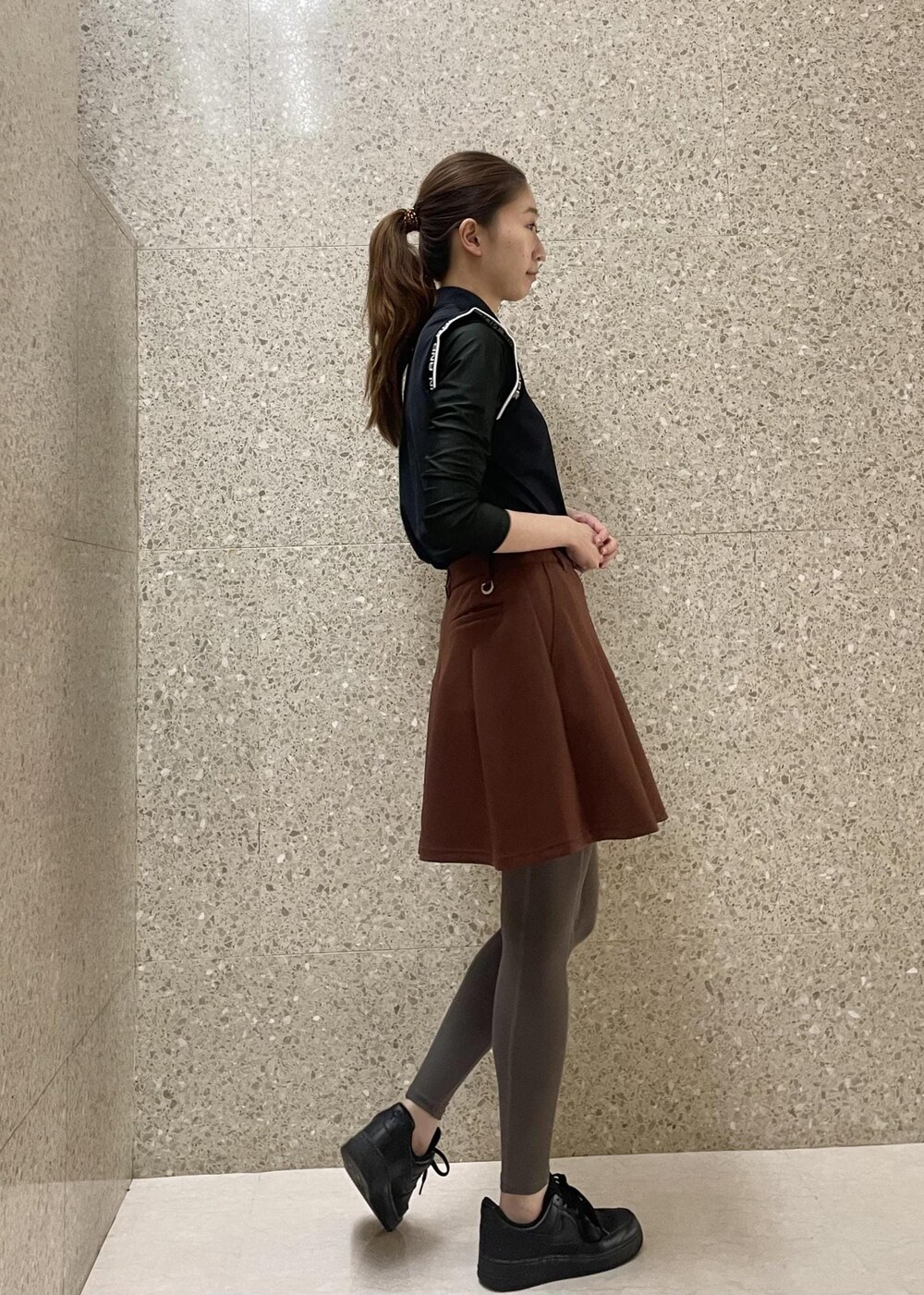 ブラック系のTシャツ/カットソー、ブラウン系のスカートを着用したレディースの秋コーディネートの4枚目の写真