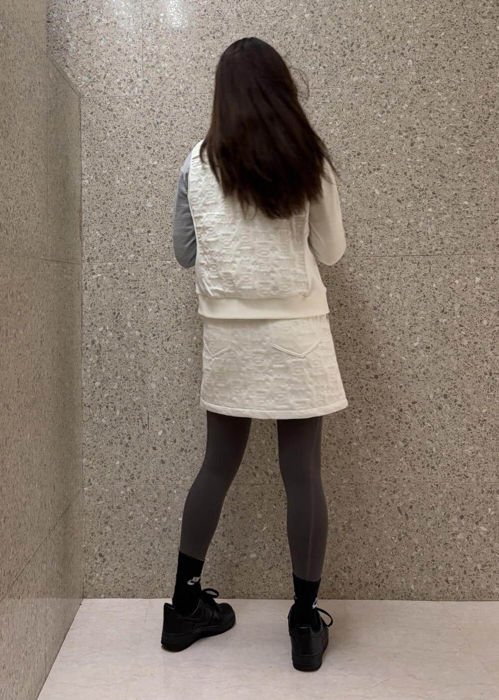 ホワイト系のTシャツ/カットソー、ホワイト系のブルゾン、グレー系のニット/セーターを着用したレディースの秋コーディネートの4枚目の写真