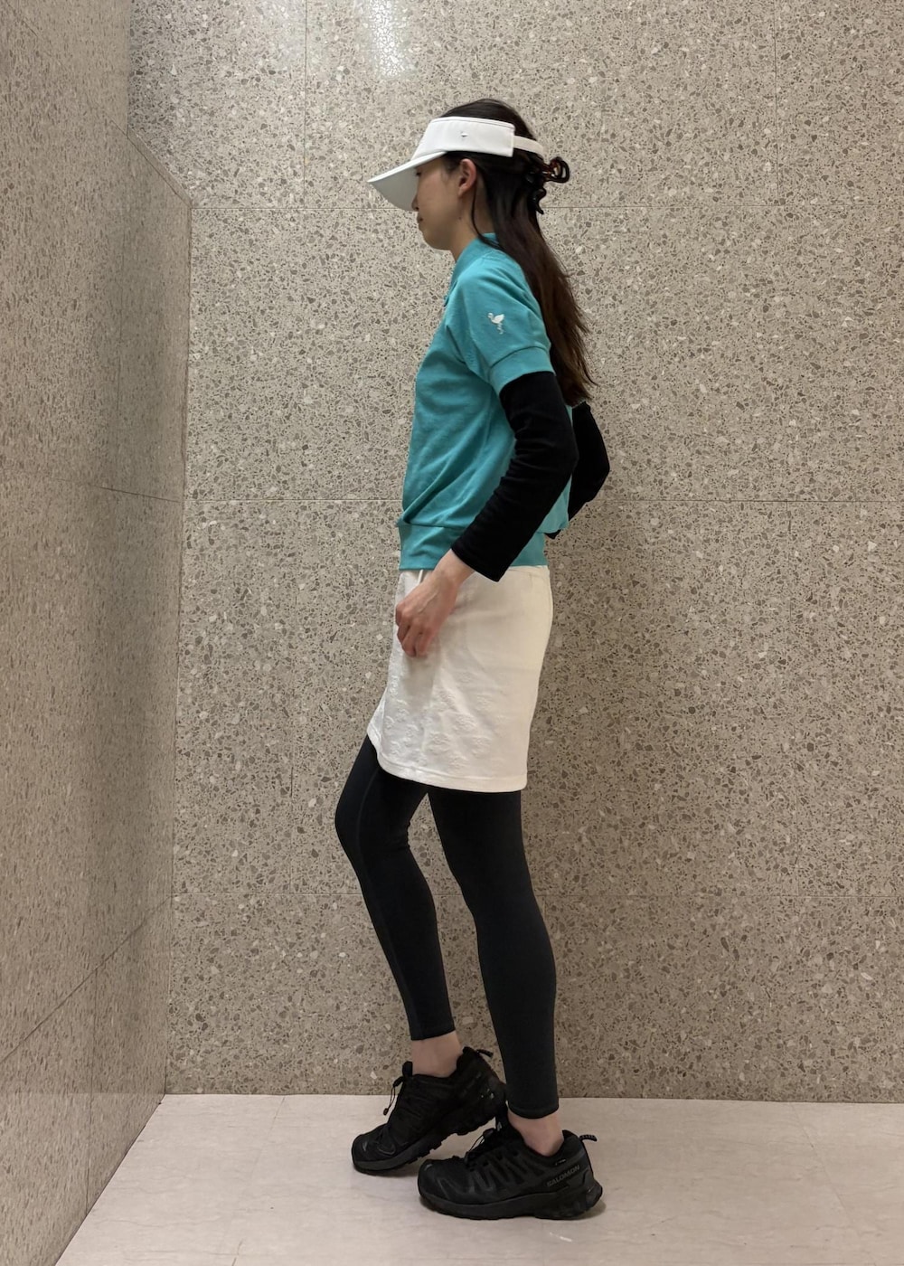 ホワイト系のスカート、ブルー系のポロシャツ、ホワイト系のサンバイザーを着用したレディースの春コーディネートの3枚目の写真