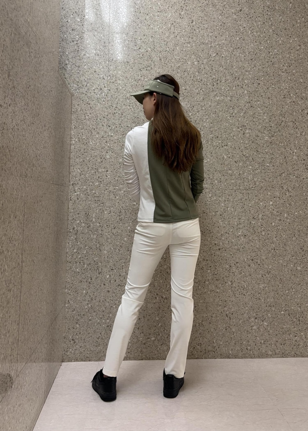 グリーン系のTシャツ/カットソー、ホワイト系のその他パンツ、グリーン系のサンバイザーを着用したレディースの秋コーディネートの4枚目の写真