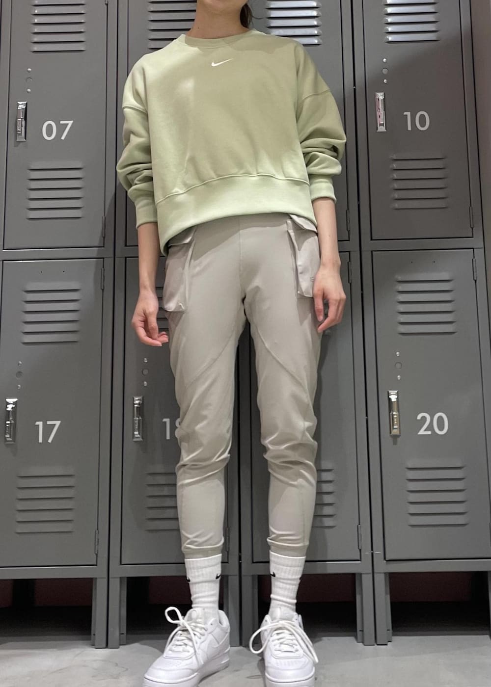 ホワイト系のスニーカー、グリーン系のスウェット、グレー系のレギンス/スパッツを着用したレディースの冬コーディネートの2枚目の写真