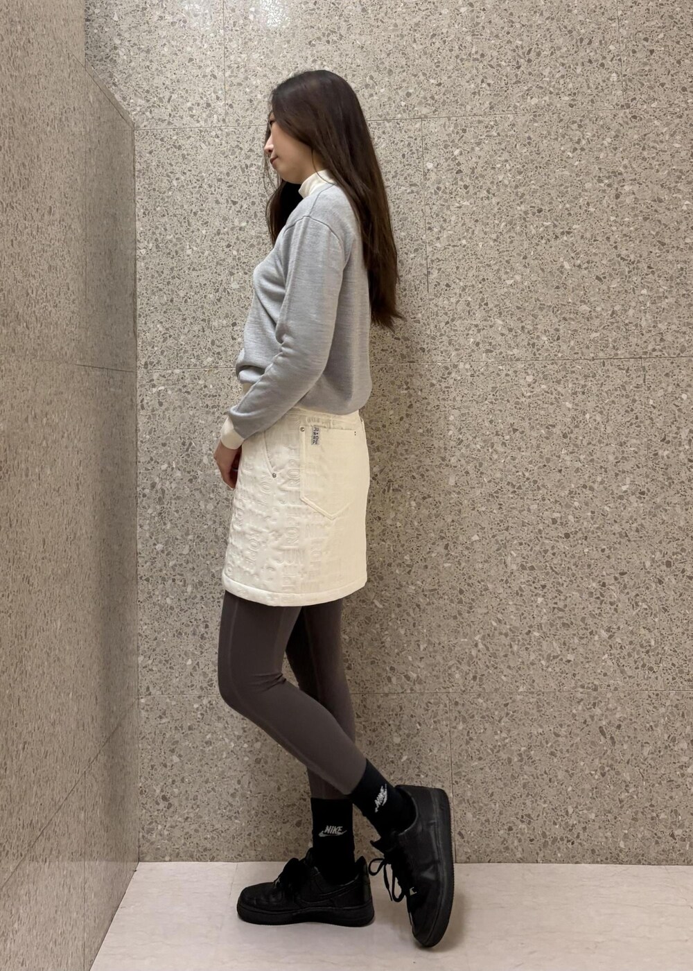 ホワイト系のTシャツ/カットソー、グレー系のニット/セーター、ホワイト系のスカートを着用したレディースの秋コーディネートの4枚目の写真