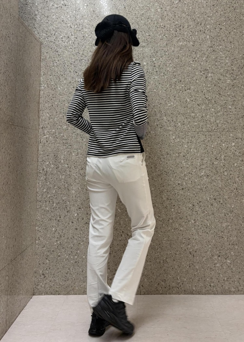 ホワイト系のその他パンツ、ブラック系のTシャツ/カットソー、ブラック系のキャップを着用したレディースの冬コーディネートの3枚目の写真