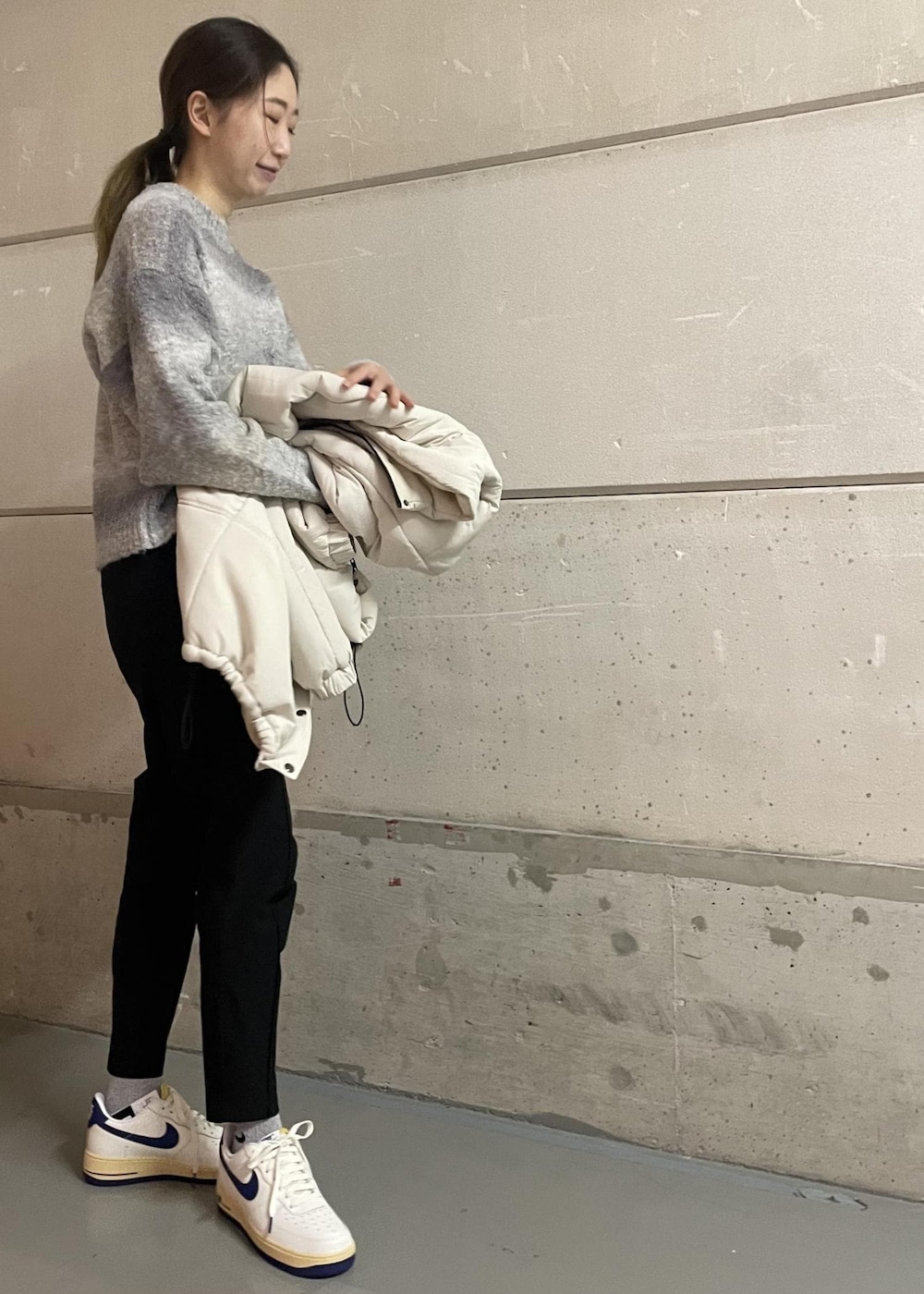 ブラック系のその他パンツ、ホワイト系のスニーカー、グレー系のニット/セーターを着用したレディースの冬コーディネートの4枚目の写真