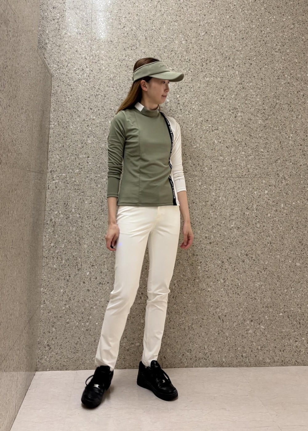 グリーン系のTシャツ/カットソー、ホワイト系のその他パンツ、グリーン系のサンバイザーを着用したレディースの秋コーディネートの2枚目の写真