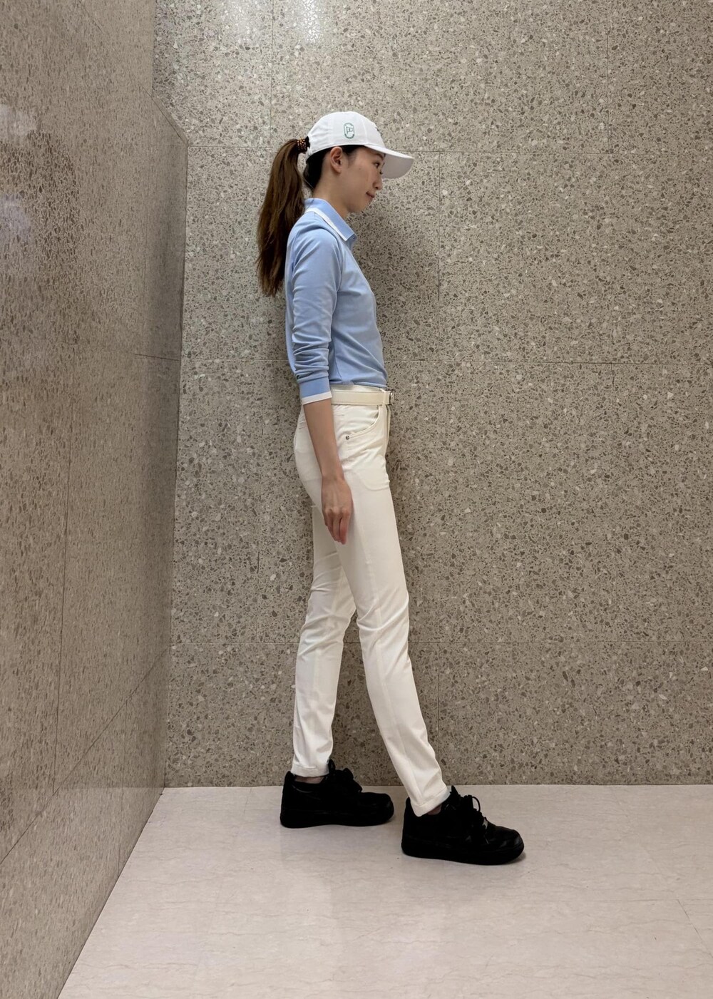 ブルー系のポロシャツ、ホワイト系のその他パンツ、ホワイト系のベルトを着用したレディースの秋コーディネートの2枚目の写真