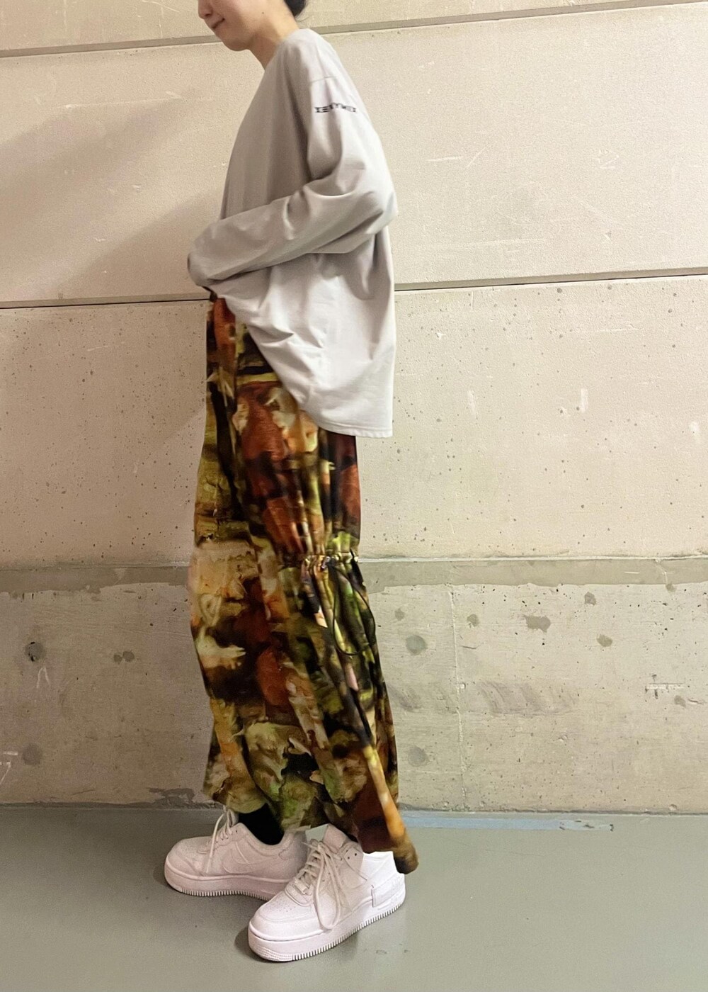 ホワイト系のスニーカー、イエロー系のワンピース、グレー系のTシャツ/カットソーを着用したレディースの冬コーディネートの2枚目の写真