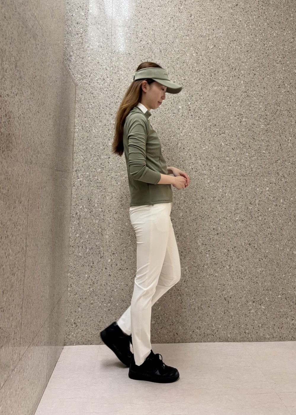 グリーン系のTシャツ/カットソー、ホワイト系のその他パンツ、グリーン系のサンバイザーを着用したレディースの秋コーディネートの3枚目の写真