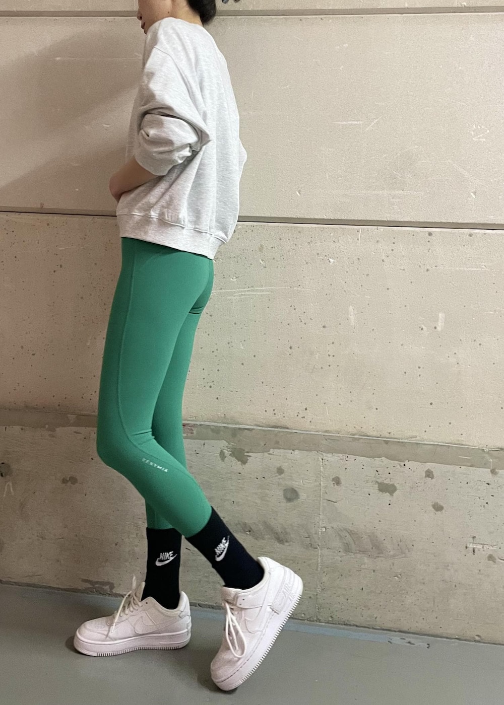 ホワイト系のスニーカー、グレー系のスウェット、グリーン系のレギンス/スパッツを着用したレディースの冬コーディネートの3枚目の写真