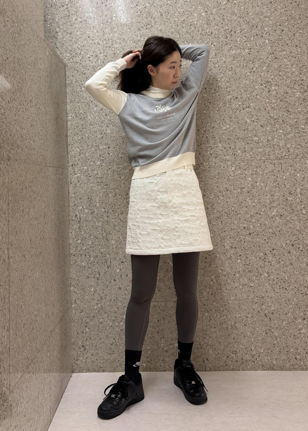 ホワイト系のTシャツ/カットソー、グレー系のニット/セーター、ホワイト系のスカートを着用したレディースの秋コーディネートの5枚目の写真