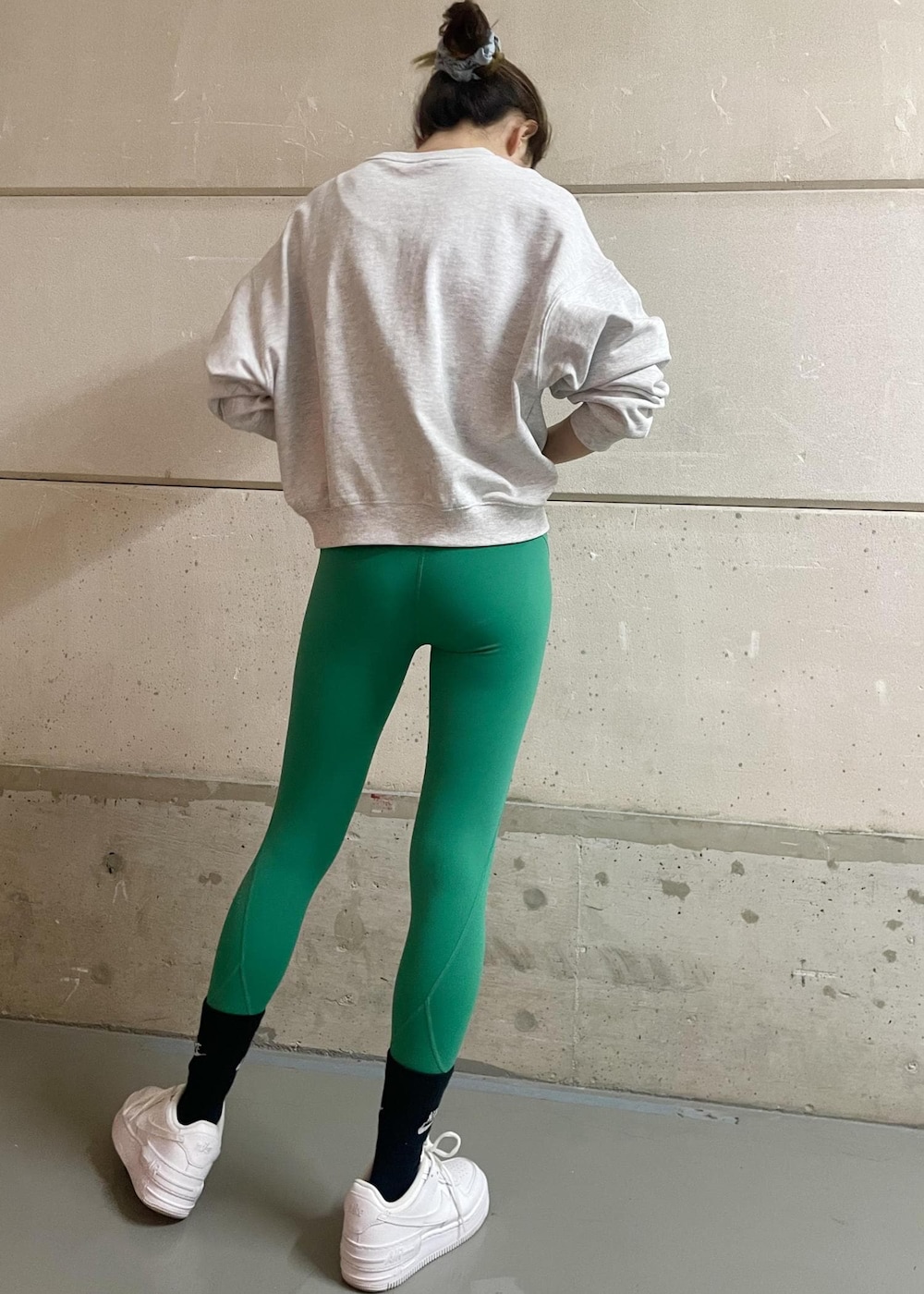 ホワイト系のスニーカー、グレー系のスウェット、グリーン系のレギンス/スパッツを着用したレディースの冬コーディネートの2枚目の写真