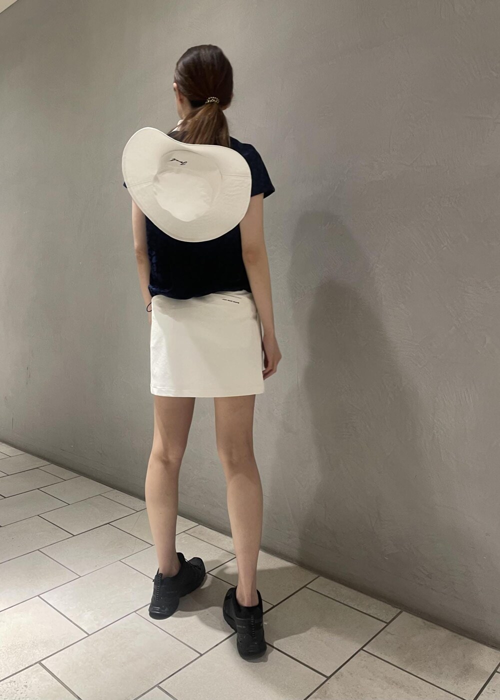 ホワイト系のスカート、ブルー系のTシャツ/カットソー、ホワイト系のハットを着用したレディースの春コーディネートの3枚目の写真