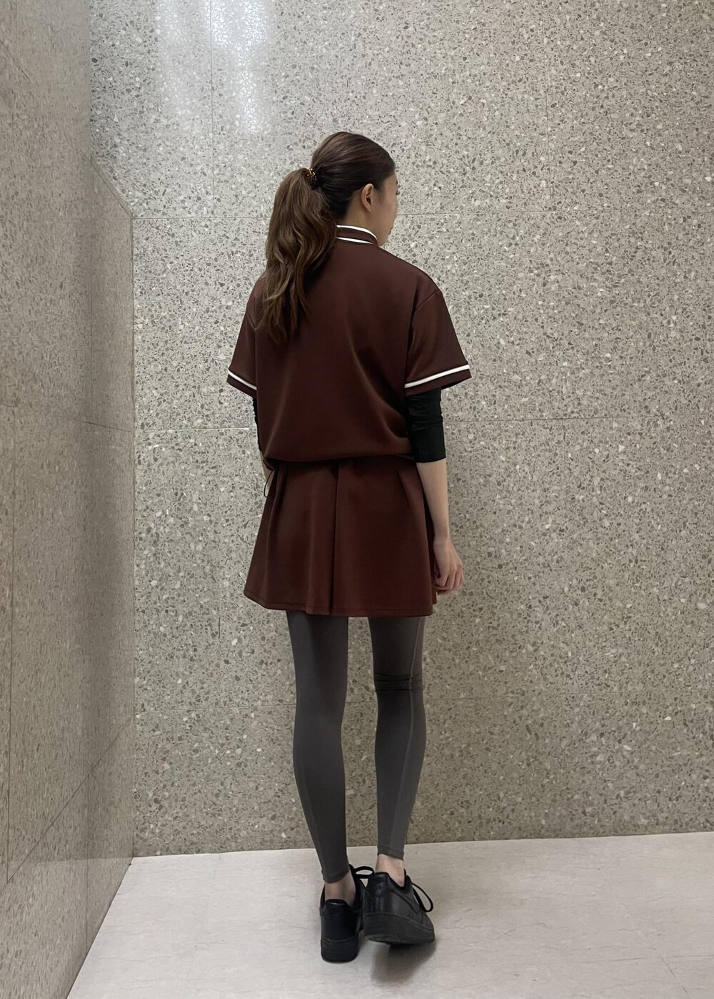 ブラウン系のスカート、ブラウン系のTシャツ/カットソーを着用したレディースの秋コーディネートの5枚目の写真