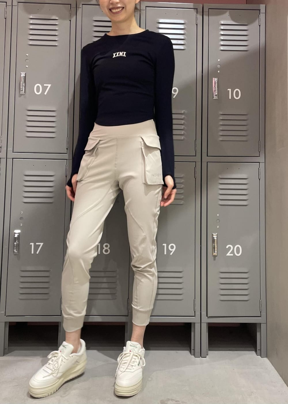 ブラック系のTシャツ/カットソー、ホワイト系のスニーカー、グレー系のレギンス/スパッツを着用したレディースの冬コーディネートの4枚目の写真