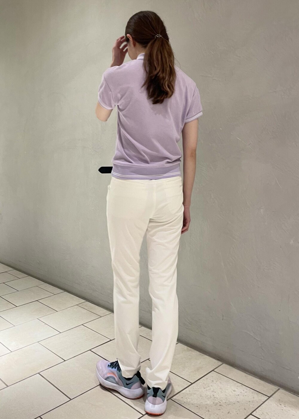 パープル系のポロシャツ、ホワイト系のその他パンツ、ブラック系のベルトを着用したレディースの春コーディネートの3枚目の写真