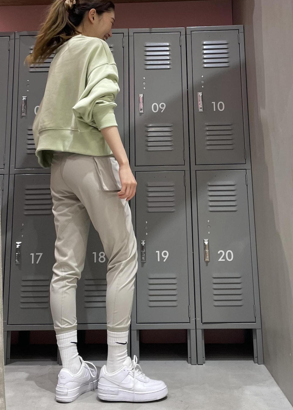 ホワイト系のスニーカー、グリーン系のスウェット、グレー系のレギンス/スパッツを着用したレディースの冬コーディネートの3枚目の写真