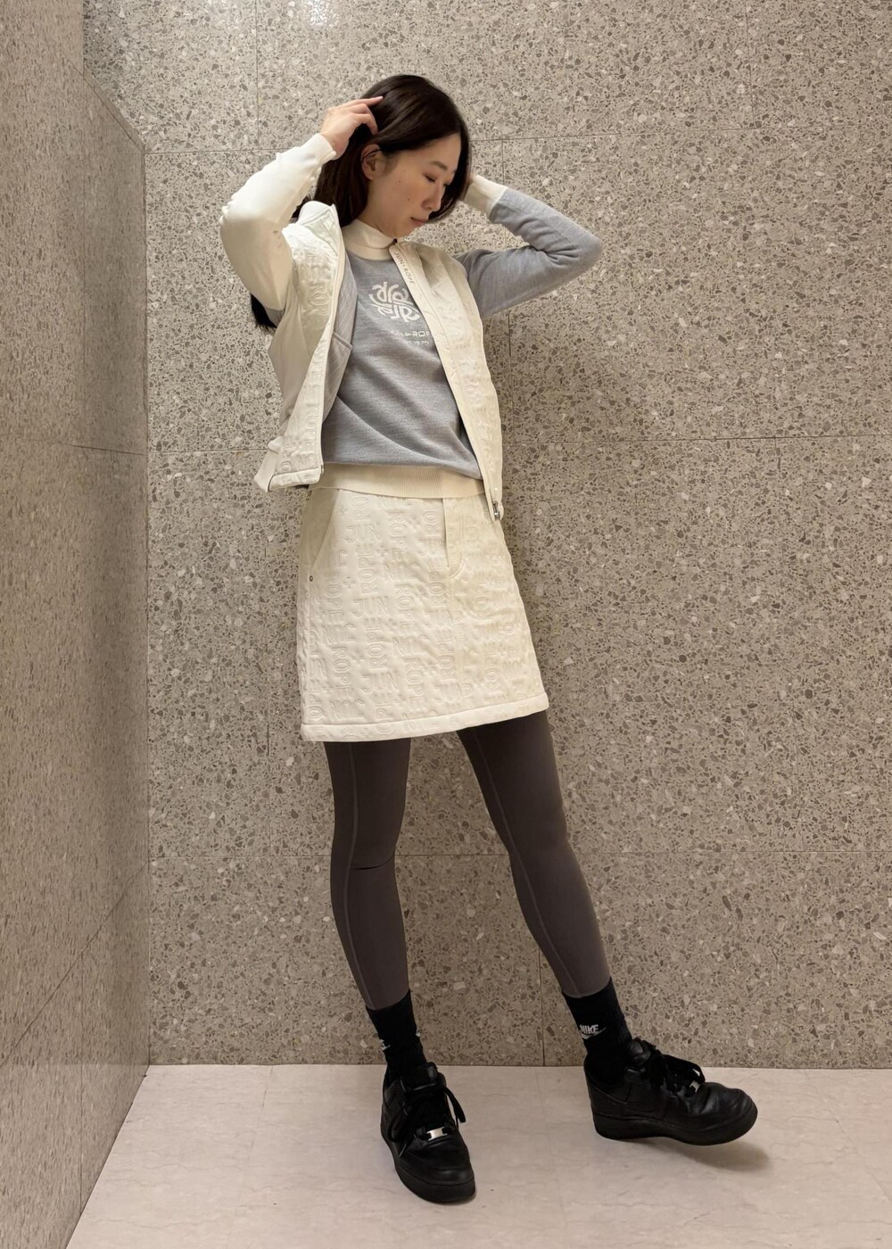 ホワイト系のTシャツ/カットソー、ホワイト系のブルゾン、グレー系のニット/セーターを着用したレディースの秋コーディネートの7枚目の写真