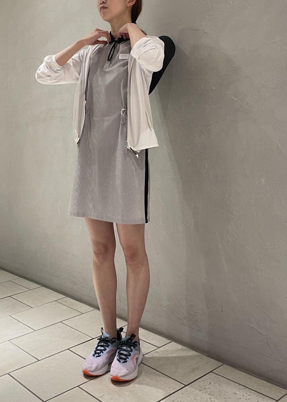 ブラック系のワンピース、ホワイト系のパーカー、ブラック系のハットを着用したレディースの春コーディネートの3枚目の写真