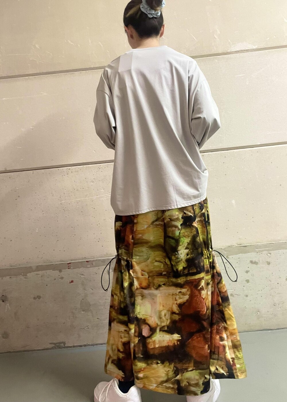 ホワイト系のスニーカー、イエロー系のワンピース、グレー系のTシャツ/カットソーを着用したレディースの冬コーディネートの3枚目の写真