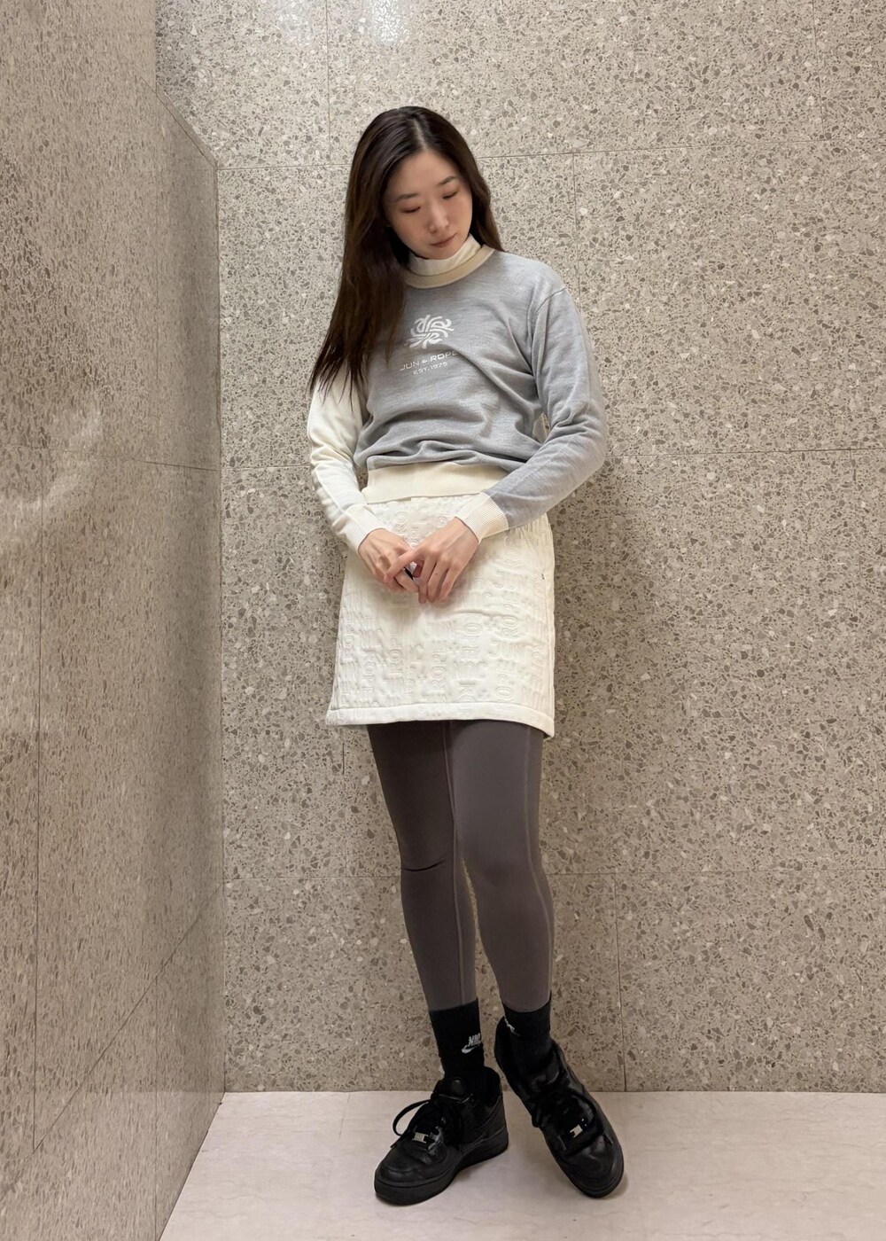 ホワイト系のTシャツ/カットソー、グレー系のニット/セーター、ホワイト系のスカートを着用したレディースの秋コーディネートの6枚目の写真