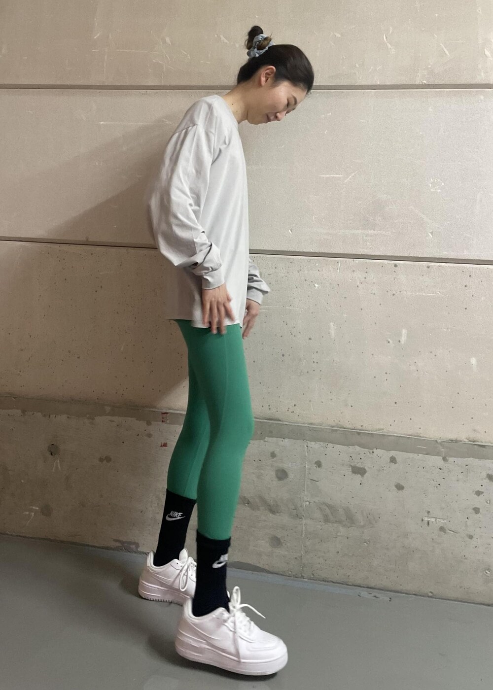 ホワイト系のスニーカー、グレー系のTシャツ/カットソー、グリーン系のレギンス/スパッツを着用したレディースの冬コーディネートの3枚目の写真