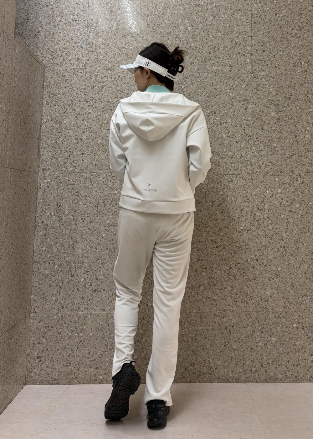 ホワイト系のブルゾン、グリーン系のニット/セーター、ホワイト系のサンバイザーを着用したレディースの冬コーディネートの3枚目の写真