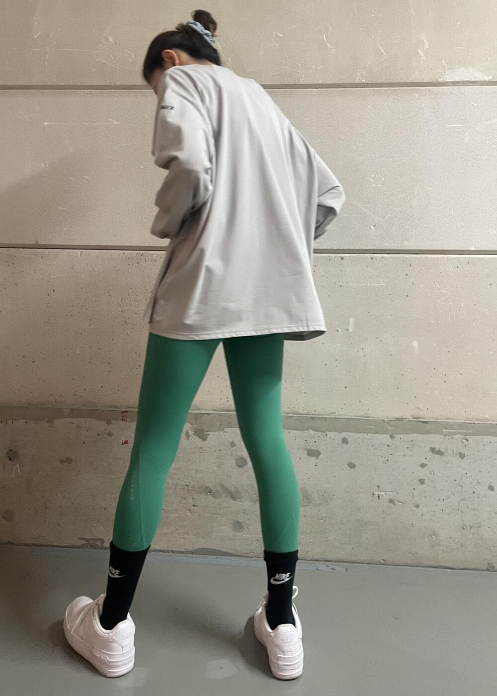 ホワイト系のスニーカー、グレー系のTシャツ/カットソー、グリーン系のレギンス/スパッツを着用したレディースの冬コーディネートの5枚目の写真