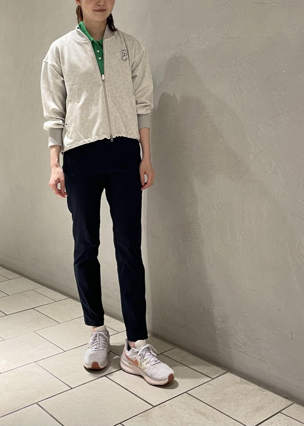 グレー系のブルゾン、グリーン系のポロシャツ、ブルー系のその他パンツを着用したレディースの夏コーディネートの4枚目の写真