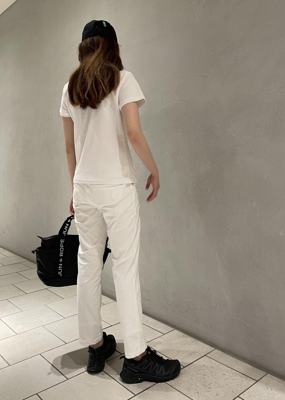 ブラック系のハンドバッグ、ホワイト系のその他パンツ、グレー系のポロシャツを着用したレディースの春コーディネートの4枚目の写真