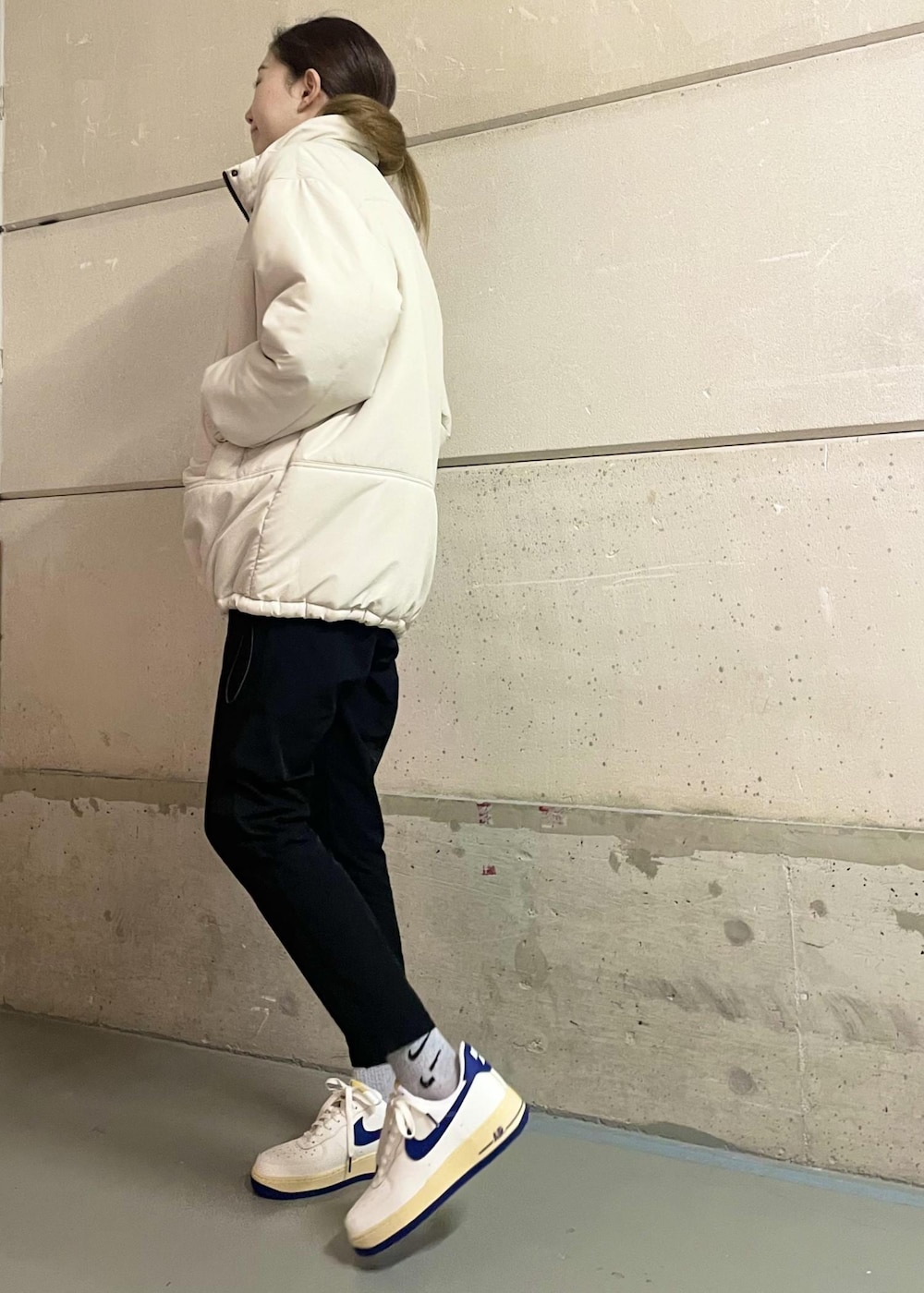 ブラック系のその他パンツ、ホワイト系のスニーカー、グレー系のニット/セーターを着用したレディースの冬コーディネートの2枚目の写真