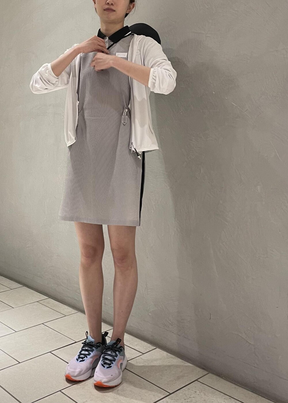 ブラック系のワンピース、ホワイト系のパーカー、ブラック系のハットを着用したレディースの春コーディネートの5枚目の写真