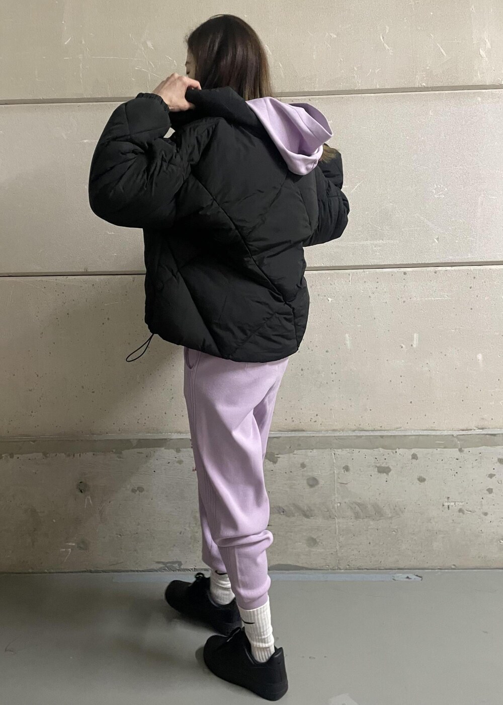 パープル系のパーカー、パープル系のその他パンツ、ブラック系のダウンジャケット/コートを着用したレディースの冬コーディネートの2枚目の写真