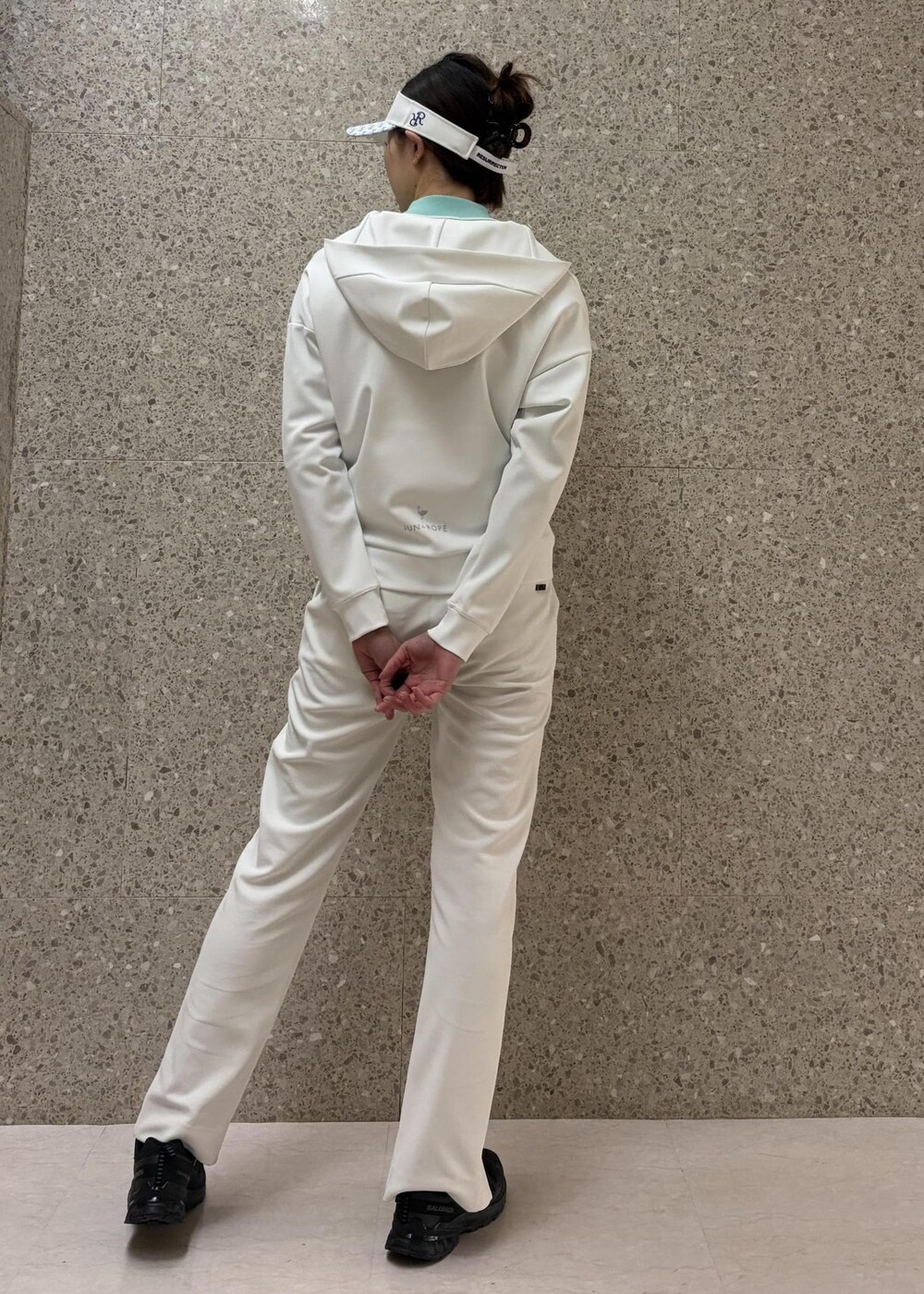 ホワイト系のブルゾン、グリーン系のニット/セーター、ホワイト系のサンバイザーを着用したレディースの冬コーディネートの4枚目の写真