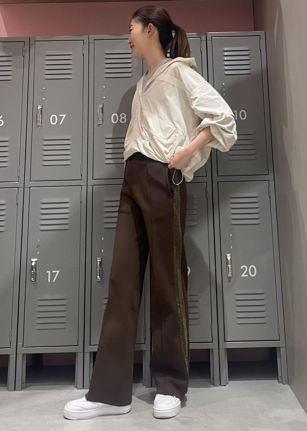 ホワイト系のスニーカー、ホワイト系のその他アウター、ブラウン系のその他パンツを着用したレディースの冬コーディネートの2枚目の写真