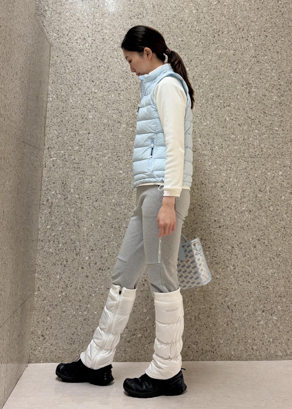 グレー系のその他パンツ、ブルー系のダウンベスト、ホワイト系のTシャツ/カットソーを着用したレディースの冬コーディネートの4枚目の写真