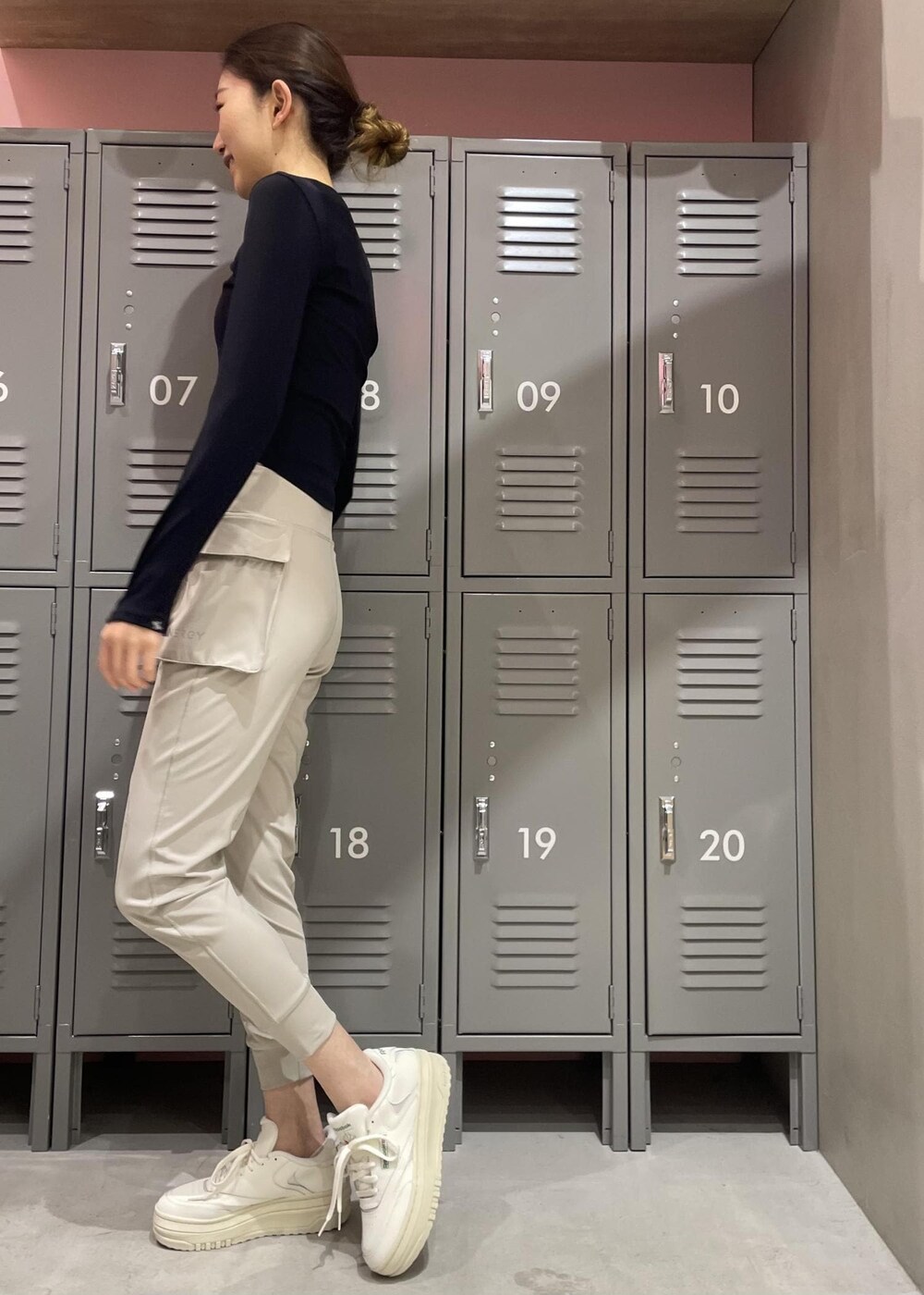 ブラック系のTシャツ/カットソー、ホワイト系のスニーカー、グレー系のレギンス/スパッツを着用したレディースの冬コーディネートの2枚目の写真