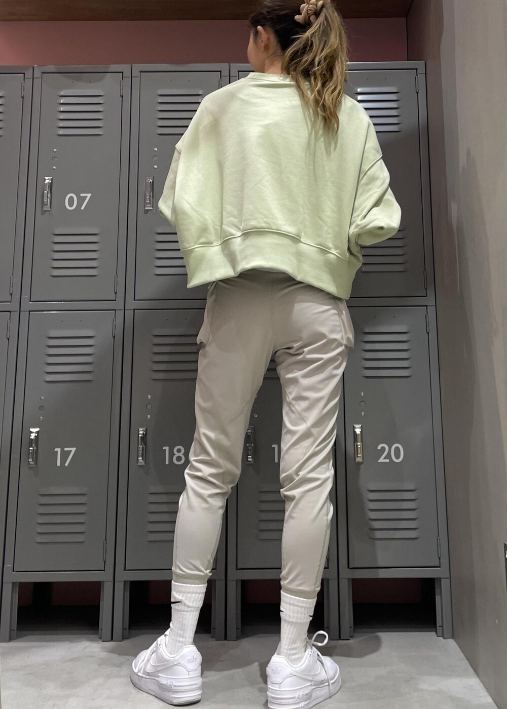 ホワイト系のスニーカー、グリーン系のスウェット、グレー系のレギンス/スパッツを着用したレディースの冬コーディネートの4枚目の写真