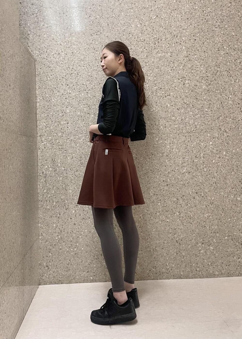 ブラック系のTシャツ/カットソー、ブラウン系のスカートを着用したレディースの秋コーディネートの2枚目の写真